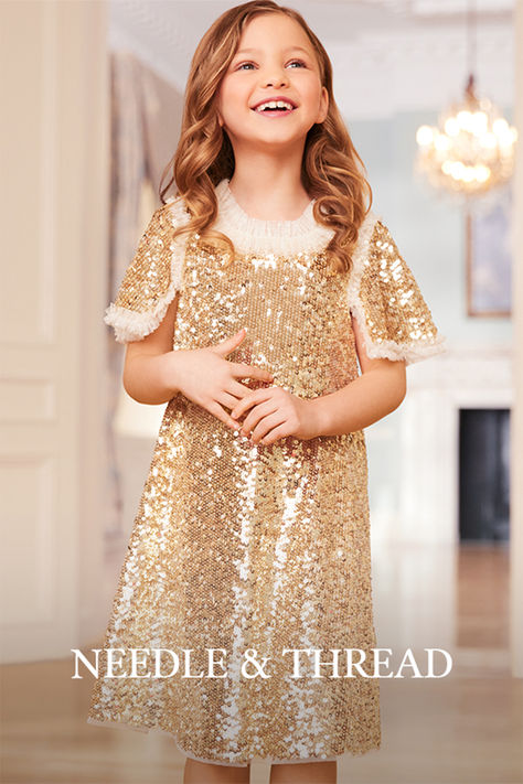 The Matilda Dress in Gold. This beautiful dress is decorated with shimmering sequins, creating an ultimate sparkle. Designed with square cut sleeves trimmed with tulle ruffles to add a Needle & Thread signature look. Update your little one's wardrobe with the ultimate fairy-tale dress of the season.