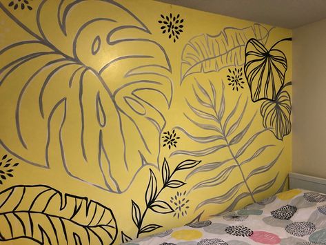 Plant leaves painted on a wall mural in black, grey and white on a yellow wall. Yellow Wall Murals Painted, Monstera Wall Mural, Monstera Wall Painting, Boho Murals, Monstera Mural, Painted Wall Mural, Leaf Mural, Garage Redo, Bedroom Wall Mural