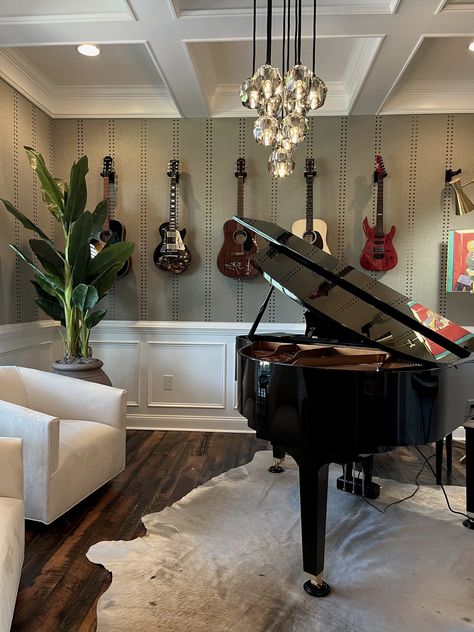 Music Room interior design. Piano on cowhide rug. Two side chairs. Vertical wallpaper design. Guitars hanging on wall. Coffered ceiling. Hanging globes chandelier. Music Room With Piano And Guitars, Piano Room Wallpaper, Nashville Interior Design, Rustic Music Room, Farmhouse Music Room, Music Room In House, Classical Music Room, Music Room Interior Design, Funky Music Room