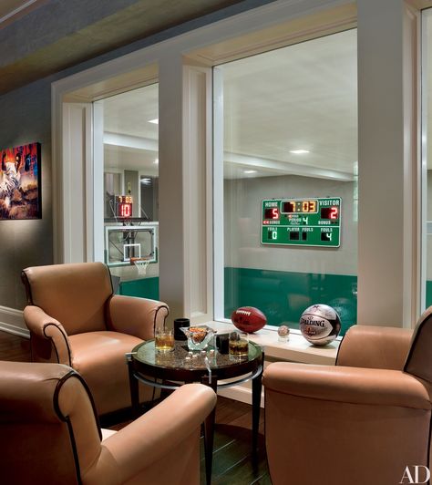 The basement recreation room of this James Paragano–designed New Jersey house overlooks the indoor basketball court, which is complete with an electronic scoreboard. Indoor Sports Court, Home Basketball Court, Recreation Room, Indoor Basketball Court, Game Room Basement, Indoor Basketball, Home Gym Decor, Sports Room, Basketball Uniforms