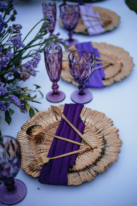 I placed three shades of purple and complimented with Purple shaded Glassware and blended up with Gold. Purple And Rose Gold Party, Royal Blue Purple And Gold Wedding, Purple And Gold Wedding Theme Decor, Purple Gold Birthday Party Decoration, Royal Purple And Gold Wedding Theme, Dark Purple And Gold Wedding, Gold Chargers Place Setting, Gold And Purple Aesthetic, Purple And Gold Party Decorations