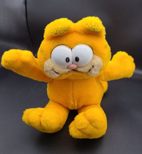 This vintage 1981 Daikin Garfield Orange Cat plush stuffed animal is a must-have for any collector or fan of the iconic orange cat. Measuring at 12 inches, this small plush toy is perfect for display or play. The brand, Daikin, is known for their high-quality stuffed animals and this vintage Garfield cat is no exception. With its soft and cuddly material, this plush toy is suitable for anyone from 3-year-olds to adults. The bright orange color and classic design make it a great addition to any collection. Don't miss out on the chance to own this piece of Garfield history. Vintage Garfield, Garfield Cat, Cat Plush, Orange Cat, Bright Orange, Plush Toy, Stuffed Animal, Stuffed Animals, Orange Color