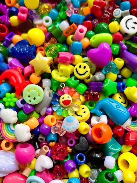 A bead mix featuring many different beads for jewelry lovers!   Here are some of the beads included:  Mini, standard, and XL pony beads of many colors Star and Heart pony beads  Varying sizes and colors of smiley face beads  Glass colorful beads  Animal beads Chunky stars and hearts  Rainbow and Rainbow flower charms    100g is around 3.5oz Smiley Face Beads, Animal Beads, Bead Soup, Kandi Kid, Kandi Bracelets, Bracelet Bead, Mia 3, Rainbow Beads, Kid Core