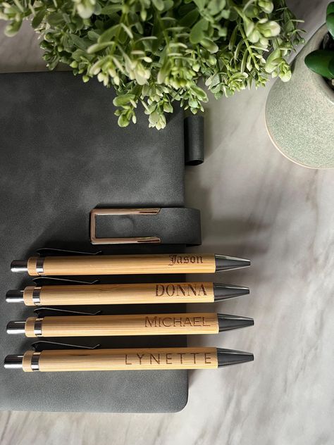 This personalised engraved bamboo pen is a unique and eco-friendly gift that combines functionality with thoughtful design.  Can be engraved with any Name, funny slogan - you name it. Made from sustainable bamboo, it features a sleek, natural finish that showcases the beauty of the wood's grain. The pen can be customised with your choice of engraving, making it an ideal gift for special occasions like birthdays, weddings, corporate events, or as a personal keepsake. The smooth writing experience Bamboo Pen, Engraved Pens, Personalised Pens, Funny Slogans, Marking Tools, Pen Tool, Eco Friendly Gifts, Promotional Gifts, Ballpoint Pens