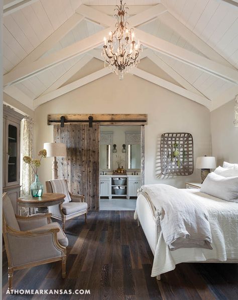 In the master bedroom, Franks employed vaulted cathedral ceilings for a spacious sense of grandeur. The shiplap application keeps the design grounded in simplicity, while a crystal chandelier adds a hint of fancifulness to the room. A sliding barn door, made of refurbished boxcar wood that Franks found at 2Brothers Reclaimed & Repurposed Inventory Sales in Menifee, conceals the entrance to the master bath. | Best in Show | At Home in Arkansas | November 2016 Rustic Farmhouse Bedroom, Farmhouse Bedroom Decor Ideas, Beautiful Bedrooms Master, Modern Farmhouse Bedroom, Decor Ikea, Farmhouse Master, Versace Home, Vaulted Ceilings, Farmhouse Bedroom Decor