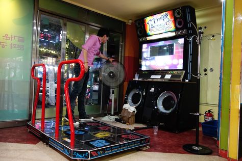 Pump it up - Arcades are still alive and well in Korea. Here a young man shows what he's got. Pump it up is the Korean version of Dance Dance Revolution. Basically, the rules are the same. Hit the arrows according to the screen. The only difference are the steps, which are top left, right, bottom left, right, and one in the middle! So challenging! Dance Revolution, Dance Dance Revolution, Pump It Up, Still Alive, Arcade Games, The Rules, Seoul, Gaming Products, Video Games