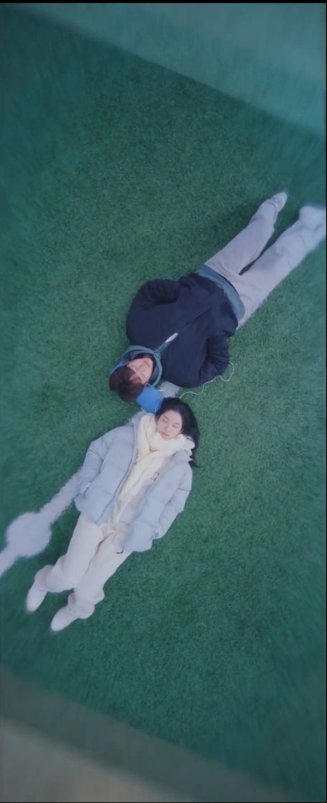 This is a scene from the kdrama "Going to you at the speed of 493kmph" aka "Love All Play". The two lead protagonist of the drama are seen laying on the green practice ground sharing a earphone together. They're eyes are closed as they enjoy each other's company and the bliss of comfort that they feel being in love. People Laying On The Ground, Sharing Earphones Couple, Going To You At A Speed Of 493km, Love All Play Kdrama Wallpaper, Two People Laying Down Reference, Sharing Earphones Aesthetic, Laying On Lap Reference, Sharing Earphones, Love All Play Kdrama