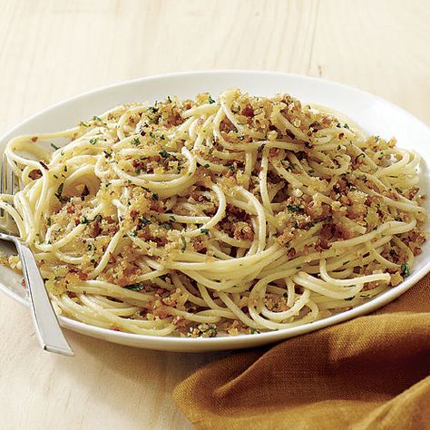 This is a twist on spaghetti aglio e olio, a traditional Italian pasta dish featuring garlic, olive oil, and chile. The fresh breadcrumbs soak up the spicy oil and garlic in a most delicious way. Be sure to brown the breadcrumbs well, or they’ll be soggy in the finished dish. Ciabatta breadcrumbs are best for this dish, but you can use any mild-flavored bread; leave the crusts on for the best texture. The anchovies are optional, but they bring complexity to the dish without making it taste ov... Extra Virgin Olive Oil Recipes, Flavored Bread, Anchovy Pasta, Spaghetti Aglio, Olive Oil Recipes, Italian Pasta Dishes, Fine Cooking, English Muffins, Idee Pasto Sano