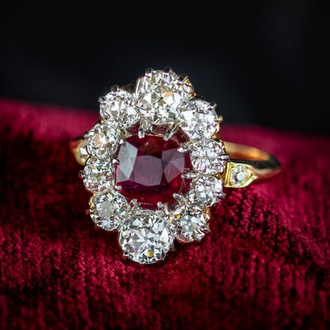 A spectacular antique Victorian cluster ring from the late 19th Century adorned with a cherry-pink cushion cut ruby at its heart complete with two gem certifications that verify the stone is natural and weighs an estimated 1.15ct with a spread of approx. 1.6ct. The ruby is framed by ten bright, chunky old mine-cut diamonds that are also detailed in the report and tested as natural with excellent SI clarity – H/I colour. They range from 0.20ct to 0.50ct and total an estimated 3 carats. The s... Antique Ruby Ring, Edwardian Engagement Ring, Antique Engagement Ring, Ruby Diamond, Diamond Cluster Ring, Vintage Jewels, Memento Mori, 3 Carat, Multi Stone Ring