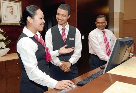 Front Desk Agents with black vests and coordinating scarf and tie Front Desk Uniform Hotel, Hotel Presentation, Resort Concept, Front Desk Agent, Hotel Uniforms, Restaurant Uniform, Muslim Photos, Hotel Jobs, Restaurant Uniforms