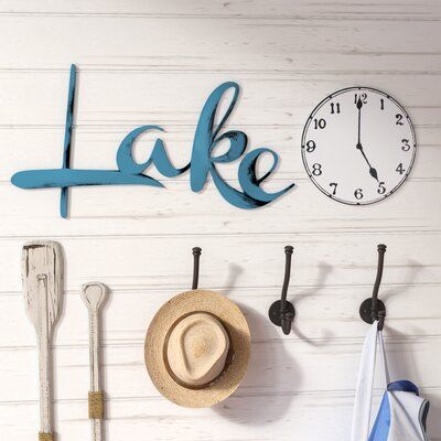 Dress up your lake house's look or just bring a bit of rustic flair into a dwelling more land-locked with this two-piece wall decor set. Made in the USA, this pleasant pair is artistically hand-painted on light-weight resistant PVC with cool hues of blue, black, and white. One piece features the scrolling word "lake", while the other is a classic clock face to let you know it's time to relax dockside. | Loon Peak® 2 Piece Lake Time Wall Décor Set in Blue | 9 H x 30 W x 0.25 D in | Wayfair | Home Modern Lake House Decor, Lake Life Decor, Lake House Wall Art, Classic Clock, Black And White One Piece, Medallion Wall Decor, Classic Clocks, Lake Time, Lake Decor