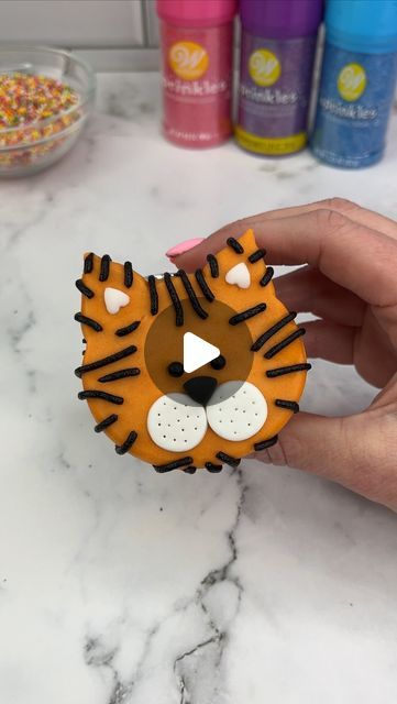 Rachel Lindsay on Instagram: "Easy tiger 🐯🧡🐯

The second animal in our ZOO 🦁🐯 
Which animal should we add next? 🥳🧡💛

I shaped my cupcakes using marbles. I added orange buttercream for the face and pressed it onto parchment paper. I popped him in the freezer for 15 minutes to allow the buttercream to firm. I then added sprinkles and black buttercream stripes.

#cupcake #cupcakedecorating #animalcupcakes #cakedbyrach #tutorial #tigercupcakes" Animal Cupcake Ideas, Animal Cupcakes Easy, Tiger Cupcakes, Black Buttercream, Character Cupcakes, Orange Buttercream, Rachel Lindsay, Mermaid Cat, Animal Cupcakes