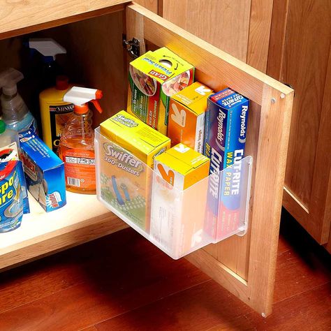 Under-Sink Storage Bins What's hiding under your kitchen sink? If the space under your sink is anything like ours, it's an overcrowded jumble of cleaning supplies, sponges and plastic bags. Here's a great way to store these items right on the door of the sink cabinet. Cut a plastic storage tub in half with a utility knife and screw it to the inside of the cabinet door through the plastic lip at the top of the tub. Plastic Storage Tubs, Inside Cabinet, Cabinet Door Storage, Sink Organization, Cheap Kitchen Cabinets, Kitchen Storage Space, Storage Tubs, Inside Cabinets, Under Sink Storage