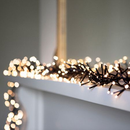 Warm White LED Cluster Fairy Lights On Black Cable -- "Dress your home in style with this gorgeous warm white cluster garland, the perfect addition to any winter wonderland. Ideal for candy cane wrapping around large Christmas trees and laying atop fireplaces" Indoor Christmas Lights, Fairy Lights Decor, Christmas Lights Garland, White Christmas Lights, Hanging Christmas Lights, Christmas Light Installation, Christmas Fairy Lights, Sparkling Christmas, Cluster Lights