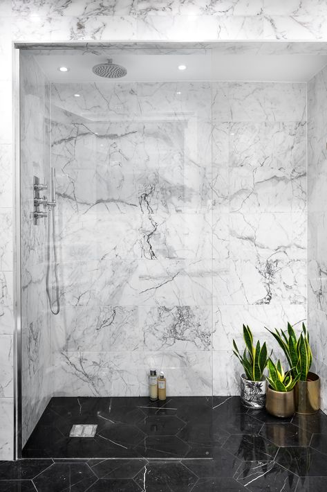 As our co-founder Michele always says, “If you don’t love marble, you don’t love life”. In this room, we replaced the bath with a walk-in shower room to give more space and a hotel-vibe. We used black marble flooring to create contrast and depth which really made the arabescato marble walls POP! We love to use plants in our projects as green is a calming neutral tone that breathes life into a space; these luscious snake plants are perfect for adding a pop of colour. Black Marble Floor, Black Marble Bathroom, Marble Bathroom Designs, White Marble Bathrooms, Marble Showers, Master Shower, Bad Inspiration, Shower Cabin, Marble Flooring