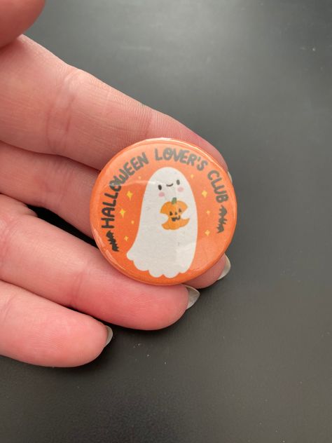 Are you a proud member of the Halloween Lover's Club? If so then this badge was made just for you! Illustrated with a little happy ghost holding a pumpkin on an orange background with the words 'Halloween Lover's Club'. The perfect way to display your love of Halloween, ghosties and all things spooky. These little button badges are made from plastic with a regular pin back. What will I receive? 1 x button badge. Badges will be packaged in a paper bag and then posted in a sturdy mailing box or ji Halloween Pins Diy, Button Pins Aesthetic, Halloween Badges Diy, Halloween Sleepover Party, Halloween Clay Pins, October Pins, Pin Ideas Button Punk, Halloween Sleepover, Halloween Club