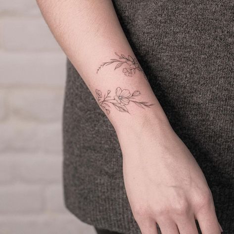 Wrist Tattoos Flower Wrap Around, Flower Tattoos Wrap Around, Floral Arm Bracelet Tattoo, Jasmine Flower Wrap Around Tattoo, Wrist Flower Tattoo Bracelet, Dainty Flower Bracelet Tattoo, Dainty Floral Wrist Wrap Tattoo, Fine Line Wrist Wrap Tattoo, Wrist Wrap Tattoos For Women Floral