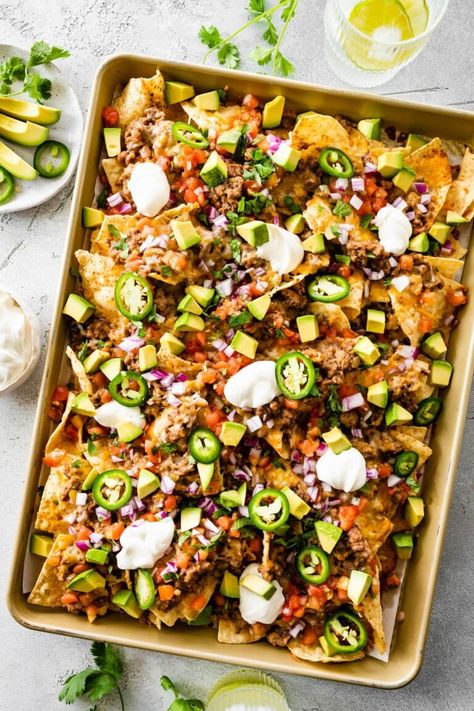 Make the best loaded nachos with this easy recipe. Tortilla chips are topped with a ground turkey refried bean mixture, cheese, tomatoes, avocado and jalapeños for the perfect appetizer or game day snack! Ground Turkey Nachos, Healthy Bean Dip, Turkey Nachos, Recipe Tortilla, Loaded Nachos Recipe, Traditional Refried Beans, Refried Bean, Sweet Potato Nachos, Loaded Nachos