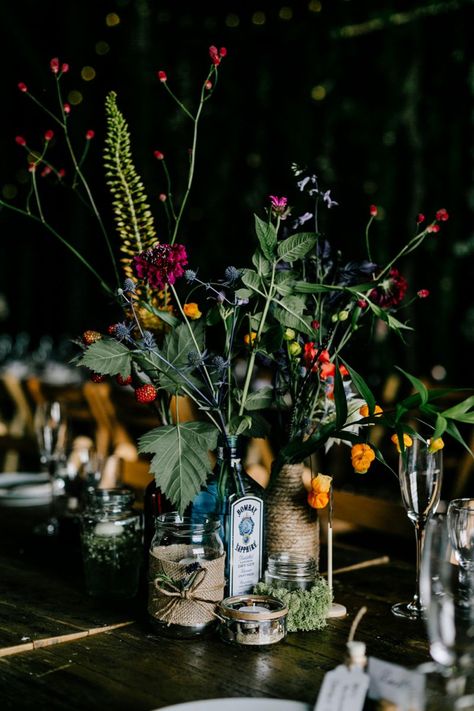 Alternative Wedding Table Centerpieces, Gin Bottle Flowers Wedding, Flowers In Gin Bottles, Flowers In Bottles Wedding, Alternative Wedding Table Decor, Gin Bottle Centrepiece, Flowers In Wine Bottles, Wedding With Bright Flowers, Pub Wedding Reception