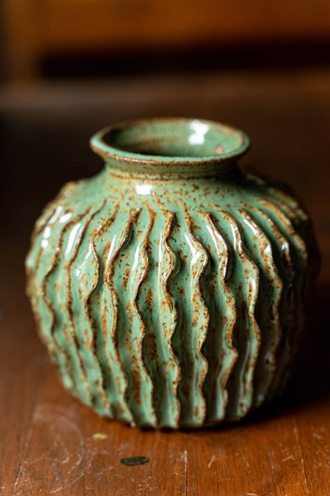 I threw this pot and then carved it in a way that suggests a cactus. Thrown with a speckled clay that shows through the green glaze.  Measures: 5.75" tall  x 6.5" wide at the widest point. Mouth is 3 inches from the inside rim. The base measures 4.5". Non Functional Ceramics, Hand Thrown Vase, Altered Wheel Thrown Pottery, Pottery Ideas Wheel Thrown Beginner, Slab Construction Ceramics, Pinch Pot Projects, Ceramic Coil Pots, Ceramic Carving Designs, Thrown Pottery Ideas