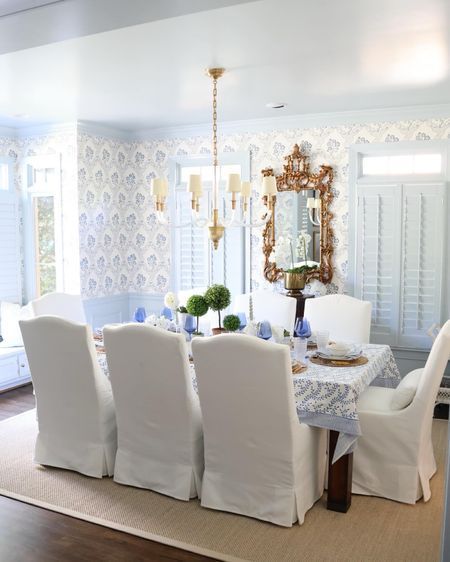 Dining room decor! White slip covered dining chairs, sisal rug, gold mirror. Blue and white grandmillennial chinoiserie wallpaper. Coastal Grandmother Dining Room, Grandmillennial Dining Room, Grandmillenial Dining Room Decor, Dining Room Decor White, Covered Dining Chairs, Slip Covered Dining Chairs, Room Decor White, Dining Room Inspo, Grandmillennial Style