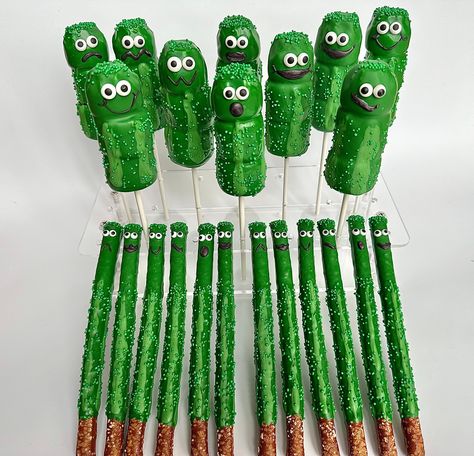 Fun and festive pickle party favors. This is a party package that includes the following treats: 12 Triple Marshmallow Pops 12 Chocolate Covered Pretzels  Each pretzel is coated in green colored chocolate and sprinkled with green nonpareils. Each triple marshmallow pop is rounded at the top and dipped in creamy green chocolate and then with more green nonpareils. Each treat is decorated with sugar eyes and chocolate mouths.  Each treat will be individually wrapped in a crystal clear cellophane sleeve and tied with green  ribbons.   Delightful Chocolates cannot be held responsible for melted or broken chocolate once the package has left our possession. We also cannot be held responsible for how the postal service treats or handles our packages. We take great pride in insulating our boxes an Pickle Birthday Party, Pickle Party, Colored Chocolate, Dipped Pretzel Rods, Green Snacks, Pickle Lover, Chocolate Covered Marshmallows, Covered Pretzels, Pretzel Rods