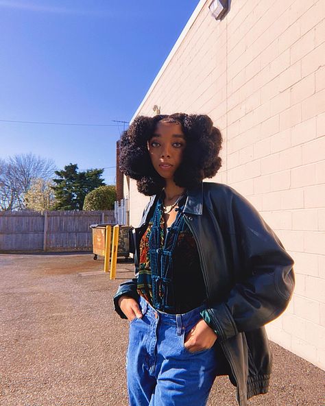 Outside besides a building with a super blue sky. Hair has a 8-10 braids with ball shape on the ends. Outfits has a green leather jacked with a button up sweater underneath and jeans. Unique African Hairstyles, Madagascar Hairstyle, Madagascar Women Hair, Futuristic Black Hairstyles, Madagascar Traditional Clothing, Afro Futurism Hairstyles, Afro Editorial Hair, Afrocentric Hairstyles, Ebony Hair