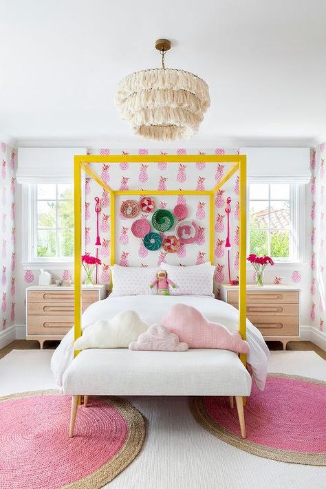 Decorative baskets hang from a wall cover in pink pineapple wallpaper over a yellow canopy bed accented with white and pink bedding. White And Pink Bedding, Twin Canopy Bed, Yellow Decor, Girl’s Room, Pink Bedding, Bed Sets, Big Girl Rooms, Teen Bedroom, Girls Room Decor