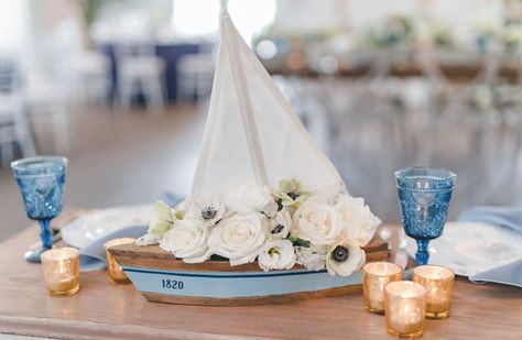 Sailboat of flowers decorating a Sweetheart table at a nautical themed wedding reception. #nauticalwedding #nautical #nauticaldecor #sailboatdecor #nauticalweddingideas Nautical Bouquet, Nautical Tablescapes, Nautical Centerpiece Ideas, Nautical Wedding Centerpieces, Nautical Wedding Reception, Sailboat Wedding, Nautical Centerpiece, Nautical Wedding Favors, Wedding Photo Walls