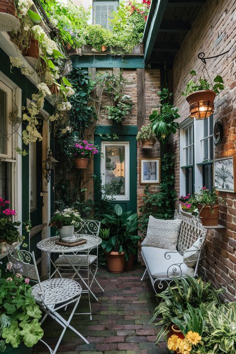 Cozy courtyard with white garden furniture, surrounded by plants and brick walls. Small Cottage House Interior, Small Patio Decorating Ideas Plants, Flower Patio Ideas, Small Balcony With Plants, Mini Patio Ideas Small Spaces, Cute Patio Ideas Small Balconies, Small Outdoor Deck Decorating, Small Courtyard Gardens Budget, Long Narrow Patio Ideas