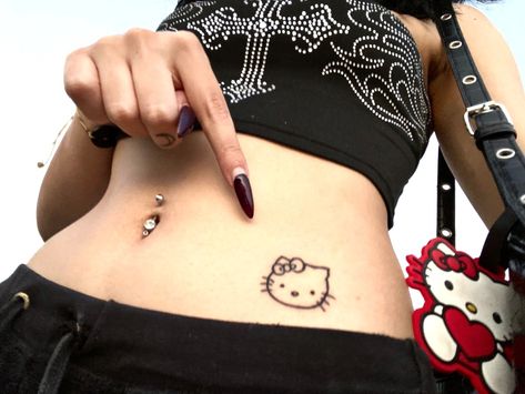 hello kitty tattoo belly button piercing y2k aesthetic Hello Kitty Tattoo Placement, Hello Kitty Hip Tattoo, Cute Belly Tattoos, Tattoos Y2k, Tattoo Pequeños Mujer, Tattoo Belly, Lower Belly Tattoo, Tatuaje Hello Kitty, Lower Belly Tattoos