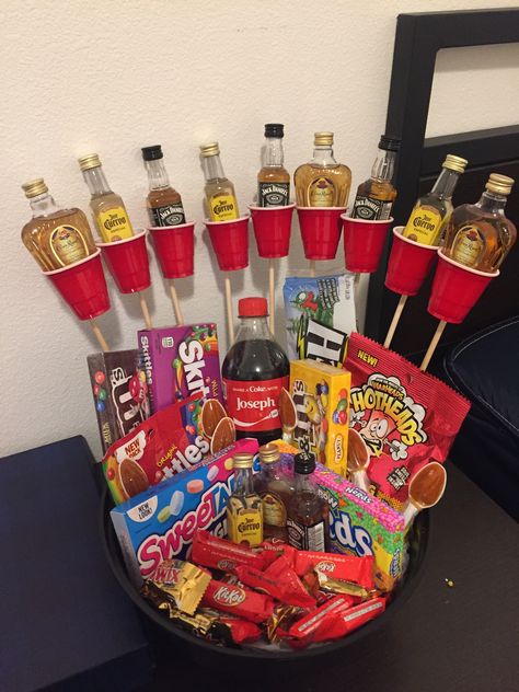 A basket with red solo shot cups, wooden sticks, mini alcohol bottle, & candies Mini Drink Gift Ideas, Mini Liquor Bottle Cake, Mini Alcohol Bottles Gifts, Drink Gift Ideas, Liquor Bottle Cake, 21st Birthday Gift Baskets, Alcohol Basket, Diy 21st Birthday Gifts, 21st Birthday Basket