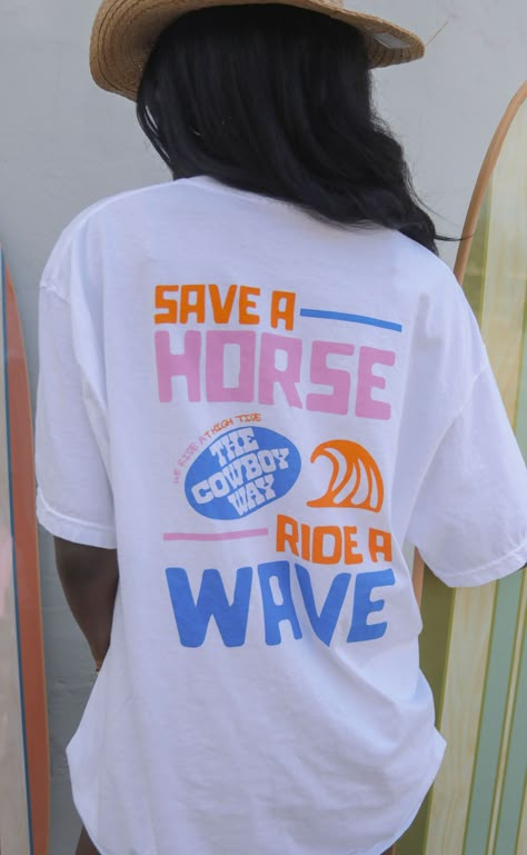 Surfs up, cowboy! Save the horse and the cowboy - ride a wave! This white tee is for all the coastal cowgirls out there that love a fun colorful graphic. 


Mary Claire is 5'9" and is wearing size medium

Heather is 5'9" and is wearing size XL for an oversized look


sizing guide: 


fits true to size - size up for an oversized fit

medium measurements: 41" bust and 28.5" length

100% cotton


WE ONLY OFFER STORE CREDIT FOR RETURNS! Feel free to email us at orders@shopriffraff.com or DM us with Cute Country Shirts For Women, Surf Tees Graphics, Surf Club Tshirt, Lake Graphic Tee, Surf Tshirt Design Ideas, Cute Tshirts Women, Save A Horse Ride A Cowboy Wallpaper, Fun Tshirt Designs, Surf Merch