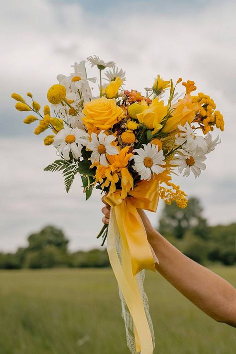 A yellow bridal bouquet with daisies and roses tied with a ribbon. Cascading Sunflower Bridal Bouquet, Sunflower And Lily Bouquet, Sun Flower Bouquet Simple, Yellow And White Bouquet, Bridal Bouquet Yellow, Yellow Themed Wedding, Daisy Wedding Bouquet, Yellow And Green Wedding, Yellow Bridal Bouquet