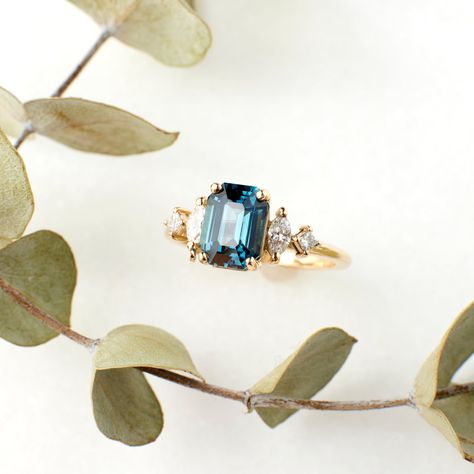 Why it's special: This stunning 2.02 carat blue-teal emerald-cut sapphire is a true standout, showcasing a captivating depth of color and natural brilliance. Emerald cuts highlight a gemstone’s clarity, as their large, open facets make inclusions more visible—this sapphire’s excellent clarity ensures a beautifully clean and luminous appearance. Elegant yet distinctive, this ring is a celebration of classic craftsmanship and exceptional sapphires. How many are available: Only one! We won't find another sapphire exactly like this one! See this ring on a hand! DETAILS Set with a 2.02 carat blue teal, emerald cut sapphire, heated and ethically sourced from Madagascar. This stone comes with an independent grading report from London Gem Labs (see last image). Set with approximately .25 carats of Blue Teal, Emerald Cut, Madagascar, Emerald, Sapphire, Gems, Gemstones, Ring, Stone