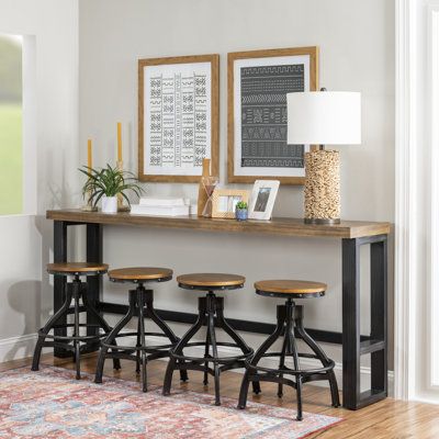 This counter height bar table and swivel stools are industrial vintage, rustic and the hand distressing enhances the overall aesthetic. The combination of materials, like the poplar veneer wood top, black hand distressed metal finish, and the extra thick metal tube base has an industrial appeal that will look great in any setting. Color: Brown | Williston Forge Wellman 4-Person Pub Table & Stool Set 36.0 H in black / whiteWood / Metal in Brown | Wayfair Rustic Pub Table, Sofa Bar Table, Sofa Bar, Accent Table Decor, Counter Height Dining Table, Counter Height Dining Sets, Wood Sofa, Table Stool, Solid Wood Dining Table