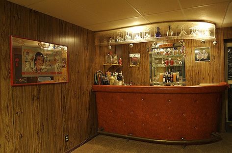 Yes, the bar is orange vinyl, the walls are wood paneling, and the carpet is shag. All are authentic.  I can only imagine the parties that have occurred in the thirty-five or so years since this basement was "finished". Well, I remember those that have occurred since I bought the house eight years ago, but I think you know what I mean... Basement Bar Wood Paneling, Retro Basement Bar, Bar Panelling, Vintage Basement Bar, Retro Basement Ideas, 70s Basement, Basement Speakeasy, 70s Bar, Vintage Basement