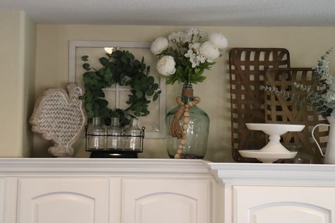 Love decorating on top of my kitchen cabinets!!! #kitchen #kitchendecor #kitchencabinetdecor Baskets Over Kitchen Cabinets, Farmhouse Top Of Cabinet Decor, Decor Above Kitchen Cabinets Simple, How To Decorate Top Of Kitchen Cabinets, Decorate Above Kitchen Cabinets Ideas, Above Cupboard Decor, Top Of Kitchen Cabinet Decor, Top Kitchen Cabinets Decor, Decorate Above Kitchen Cabinets