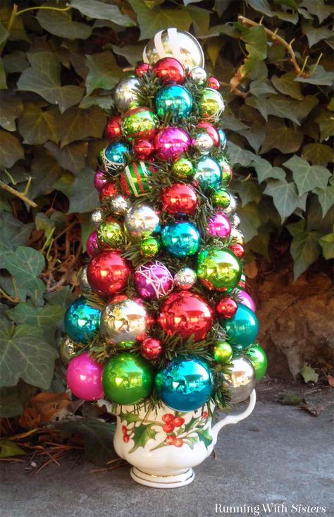 Make Shiny Brite Christmas Topiary using Christmas ornaments! This easy Christmas craft will be a stunner to decorate with for years to come! Crafts Using Christmas Ornament Balls, Christmas Ornament Tree Diy, Teacup Topiary, Christmas Ornament Topiary, Ornament Topiary, Christmas Tree Topiary, Ornament Trees, Evergreen Garland, Metallic Ball