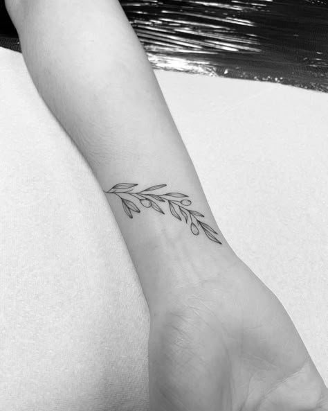 Athena Olive Branch Tattoo, Olive Branch Line Art Tattoo, Greek Wrist Tattoos, Wrist Olive Branch Tattoo, Olive Wrist Tattoo, Olive Vines Tattoo, Olive Branch Tattoo On Wrist, Olive Branch Band Tattoo, Delicate Olive Branch Tattoo