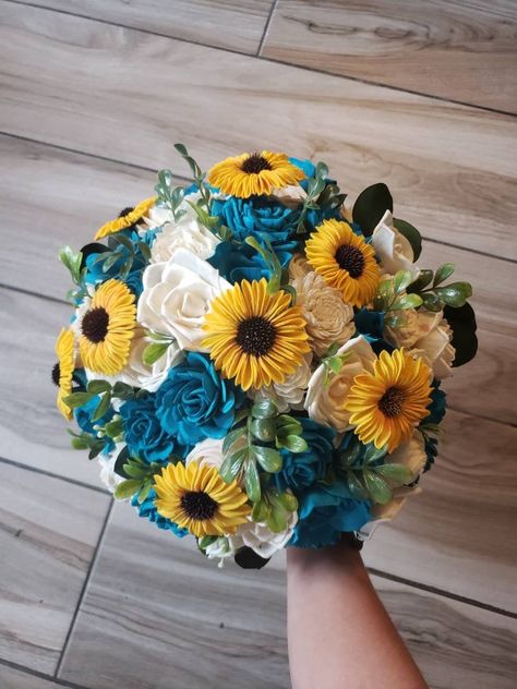 Sola wood flower wedding bouquet with turquoise flowers as well as yellow sunflowers. Greenery is a mixture of artificial and preserved. Pictured is the large 12 inch bridal. Handle is wrapped in blue ribbon and lace. Can also add matching bridesmaid bouquets, corsages and boutonnieres per request. Made to order! Each flower is hand made and painted so a slight variation in placement may occur from one bouquet to the next.Can also be made in different colors. Please message me for custom quotes. Yellow And Turquoise Wedding, Purple Flower Bouquet, Wedding August, Rustic Sunflower Wedding, Flower Wedding Bouquet, Bee Wedding, Sunflower Wedding Bouquet, Sunflower Themed Wedding, Summer Sunflower