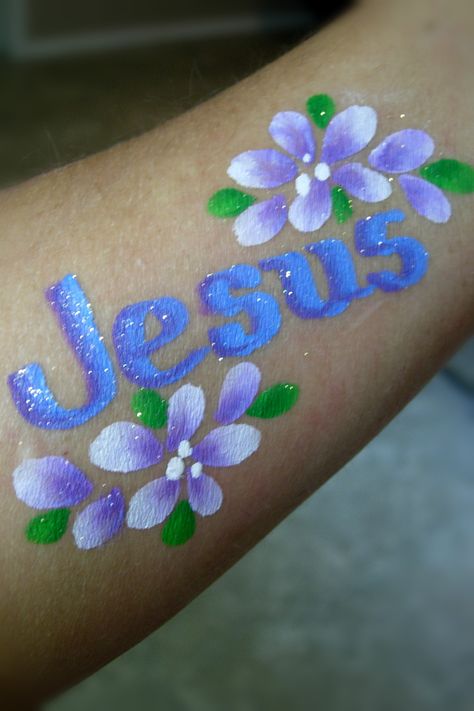 "Jesus" & Flowers on arm- Smiley Faces by Jo Christian Face Painting, Easter Face Painting, Easter Face Paint, Diy Lip Plumper, Diy Tattoo Permanent, Spring Eye Makeup, Fairy Face Paint, Face Painting For Boys, Christmas Face Painting