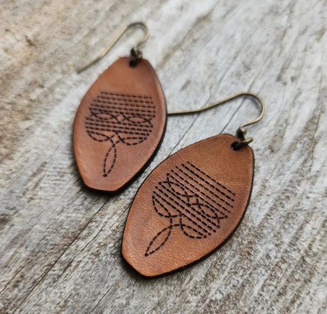 Handmade genuine leather earrings with a vintage western look. Engraved, lightly oiled then burnished to a bright shine. Finished with antique gold findings. Dimensions: 2 x 0.9 in (5.1 x 2.3 cm) Laser Gifts, Boho Leather Jewelry, Laser Engraved Earrings, Handmade Leather Jewelry, Canvas Bag Design, Western Crafts, Country Jewelry, Leather Earring, Cowgirl Jewelry