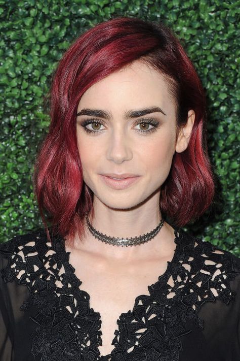 Go burgundy this spring like actress Lily Collins. To keep your tresses the focus of attention, make sure the rest of your makeup is minimal and offset the color with bold brows. Bangs Sideswept, Red Hair Celebrities, Red Hair Color Shades, Dark Red Hair Color, Red Hair Looks, Maroon Hair, Fiery Red Hair, Cherry Red Hair, Black Eyebrows