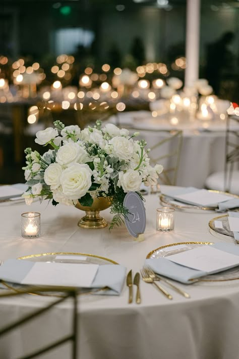 This white wedding floral centerpiece was so gorgeous! We used white roses, white lisianthus, white stock, dusty miller, and a gold container to create the look. The candles were the perfect compliment! Floral by @florafetish | Photography by @honeygemc • • • white wedding flowers white flower centerpieces wedding with candles all white flower wedding centerpieces white flower centerpiece wedding white floral centerpieces wedding low white floral centerpieces wedding All White Flower Wedding, White Flower Centerpieces Wedding, White Floral Centerpieces Wedding, White Flower Wedding Centerpieces, Wedding Centerpiece With Candles, Wedding With Candles, Wedding Centerpieces White, Flower Centerpiece Wedding, White Rose Centerpieces