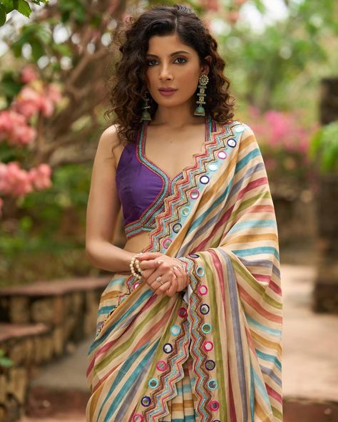 Upgrade your saree collection with our stunning multicolor striped printed saree, featuring elegant bold mirror work embroidery. Perfect for any occasion, this saree will make you stand out with its unique design and eye-catching colors. Elevate your style and make a bold statement with this one-of-a-kind saree. #sujatra #sujatraglobal #sujatrasarees #stripedsaree #printedsaree #multicolor #multicolorsaree #mirrorwork #mirrorembroidery #embroideredsaree #modernsaree Stripe Saree Blouse, Bold Mirror, Striped Blouse Designs, Mirror Work Embroidery, Saree Material, Blouse Necklines, Embellished Jumpsuit, Floral Print Sarees, Designer Kurti Patterns