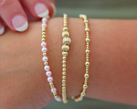 Waterproof | Tarnish Free | Hypoallergenic Bracelets: MELANIE ($49)- VICTORIA ($56)- ANGELINA ($46) Bead Material: Gold filled STRETCHY LENGTH: 6.5" OR 7" CLASP LENGTH: 6" + 1.5" EXTENSION High Performance Elastic Made in miami, made with love This stack is your ultimate accessory for effortless elegance and coastal chic. Inspired by the breezy sophistication of the Hamptons, these bracelets feature a collection of beautifully crafted ball beads in various sizes and colors, reminiscent of sun-ki Bracelets Stack, Gold Bracelets Stacked, Stack Bracelets, Preppy Bracelets, Preppy Jewelry, Coastal Charm, Jewelry Accessories Ideas, Rose Gold Pendant, Coastal Chic