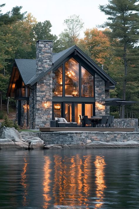 Modern lakefront cottage with stone siding large modern windows stone terrace right on the lake surrounded by trees. Unlock the charm and tranquility of lakefront living with the secrets to turning your shoreline dream into reality. Minnesota Houses, Lake Side House, Muskoka Cottages, House On The River, River Houses, Riverfront Home, Stone Terrace, Lakefront Cottage, Modern Greenhouses