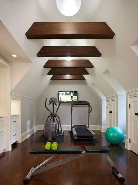 Attic home gym boasts a vaulted cieling adorned with wood beams placed over gym equipment facing a flat panel tv. Home Gym Closet, Gym Closet, Attic Library, Attic Renovation Ideas, Yoga Ashtanga, Finished Attic, Media Room Design, Attic Loft, Exercise Room