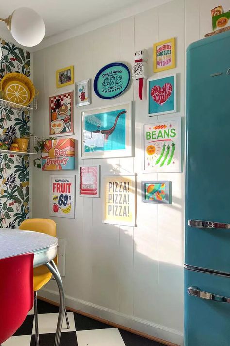 If you love gallery walls add one to your retro kitchen. This retro kitchen gallery wall is full of bright colors and positive feelings galore. We love that it matches the vibe of the colorful retro refrigerator! #BlueRetroFridge #KitchenIdeas #RetroKitchen #TheSpruce Retro Glam Kitchen, Vintage Maximalist Decor, Kitchen Glam, Retro Kitchens, Kitchen Gallery Wall, Retro Appliances, Diy Herb Garden, Retro Fridge, Kitchen Company